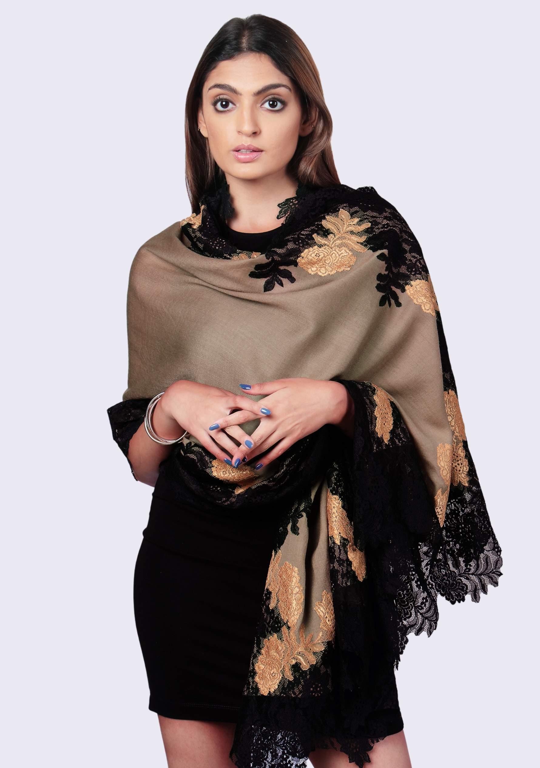 Woman wearing a beige and black lace shawl on a white background
