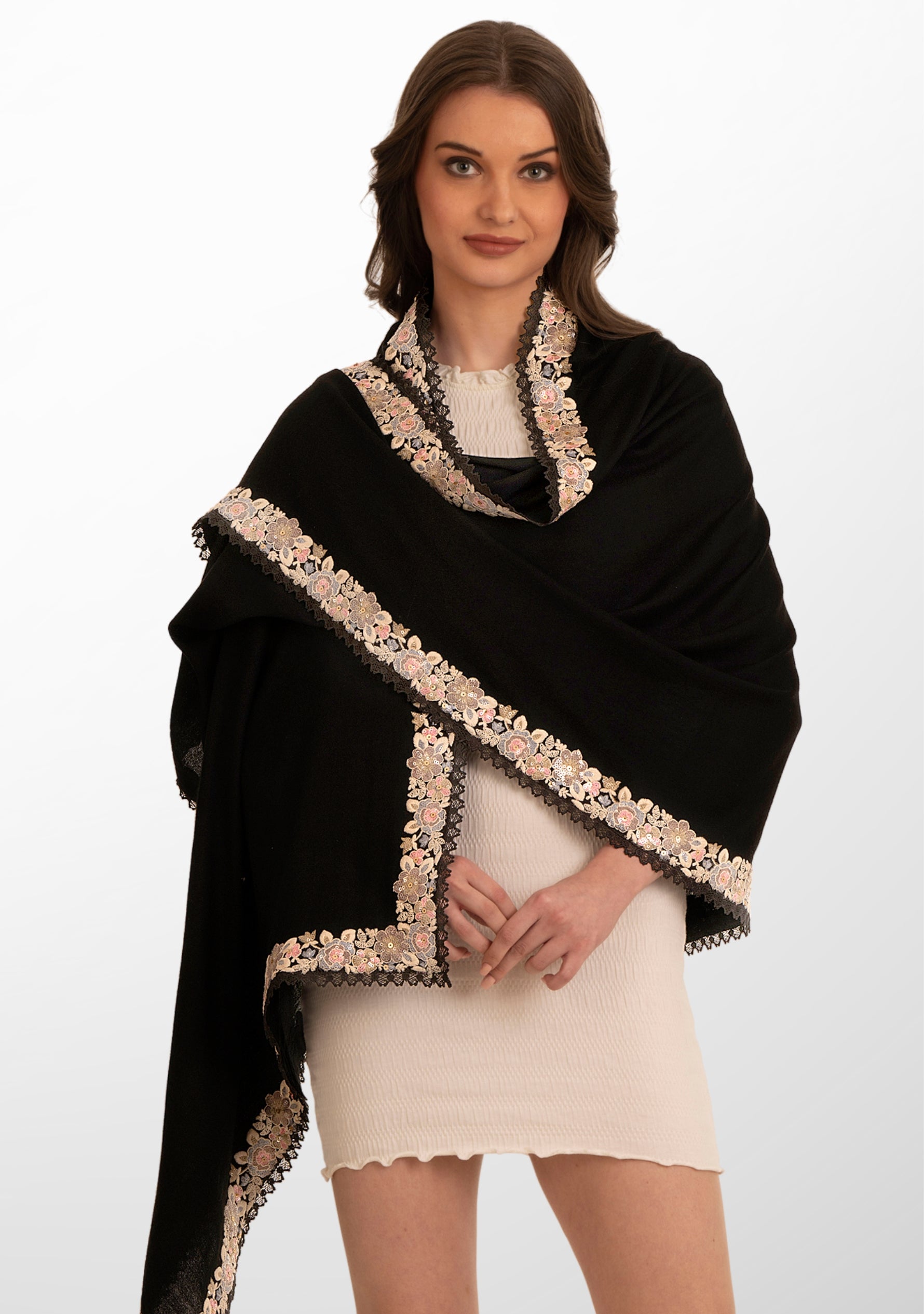 A woman wearing a black scarf with multi-colored embroidery and black lace detailing.