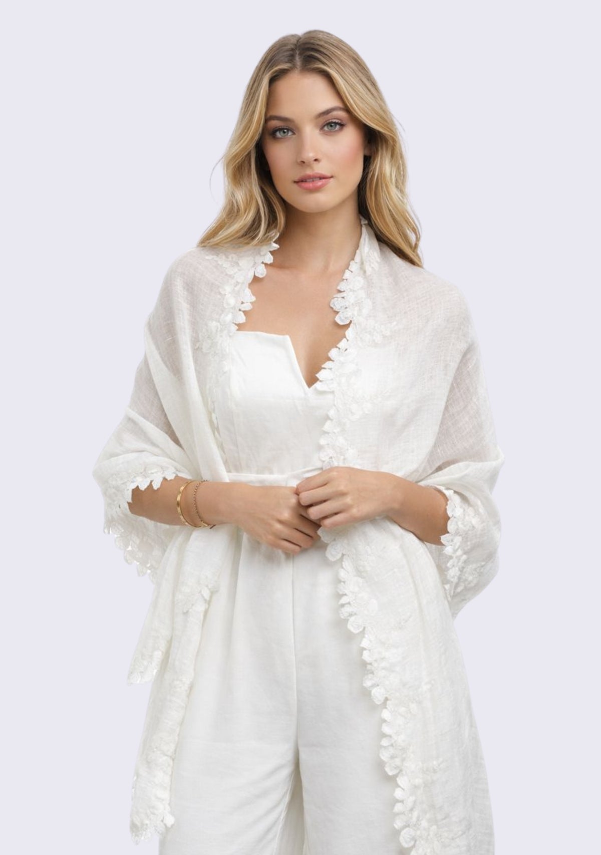 Woman wearing a white outfit with a matching linen and modal scarf on a light purple background