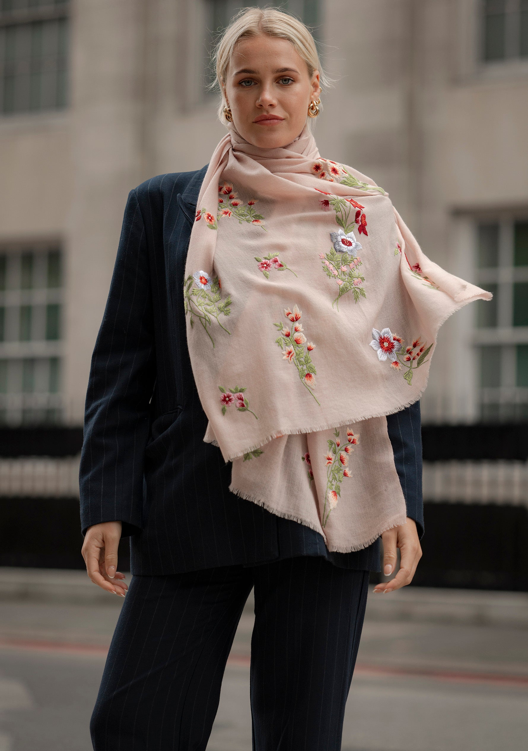 Woman wearing a floral embroidered scarf in an urban setting