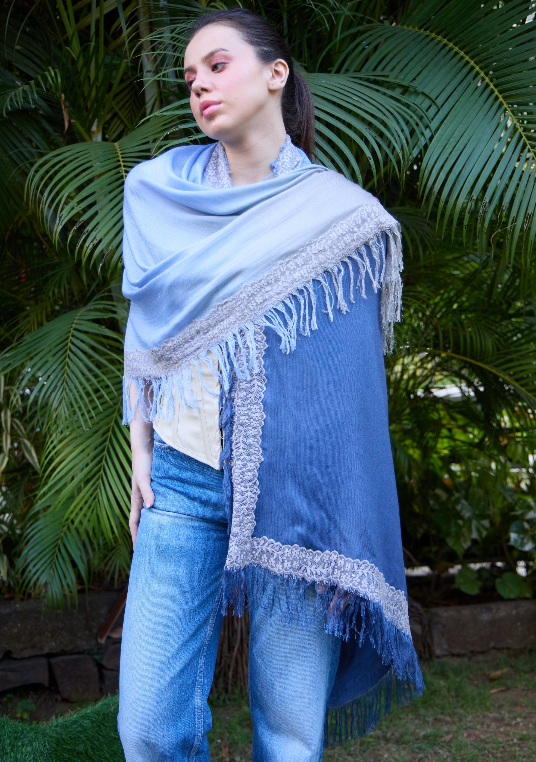 Maneesha Ruia Denim Ombré Modal & Cashmere Scarf with Mousse Lace Fringes, styled on a model, featuring a soft light blue to denim blue gradient with delicate lace trim.