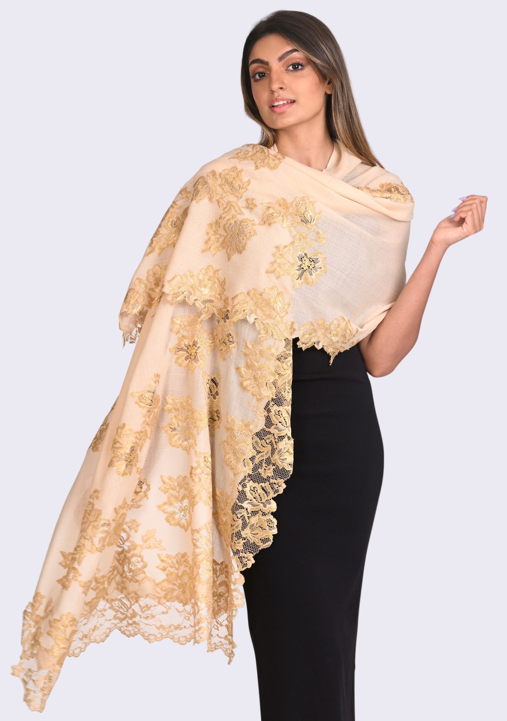 A woman wearing a beige cashmere scarf with gold Chantilly lace.