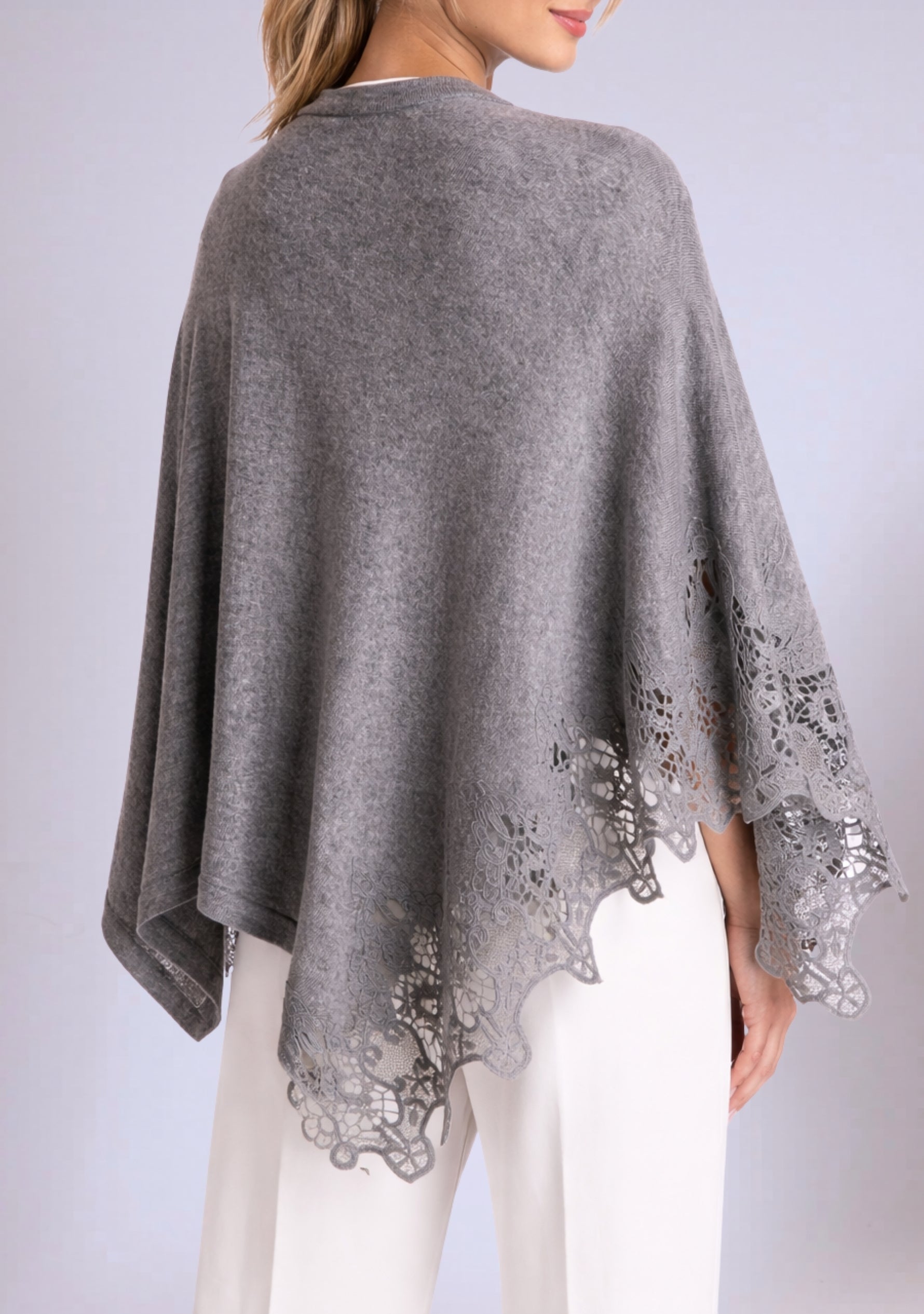 Gray poncho with lace details on a plain background