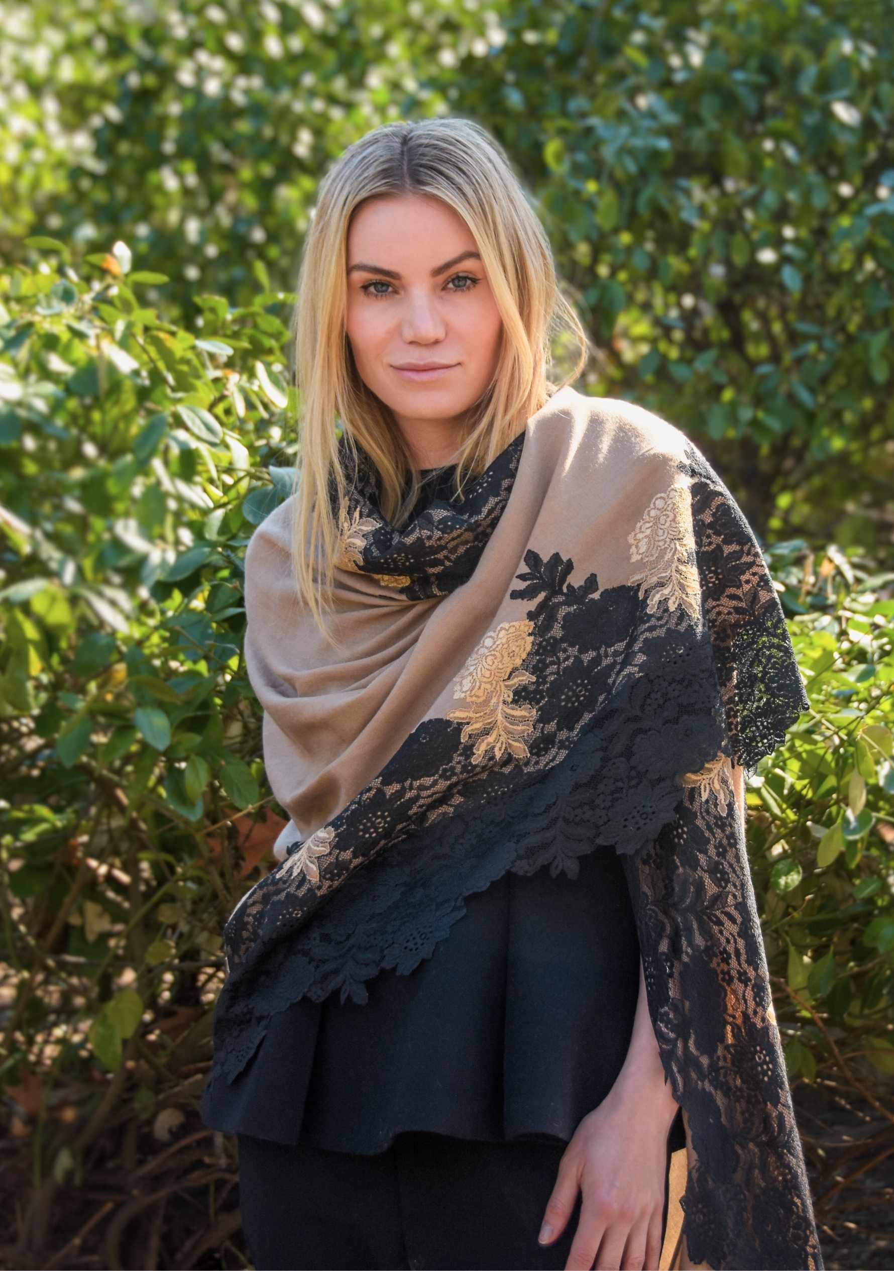 Woman wearing a beige and black patterned shawl outdoors
