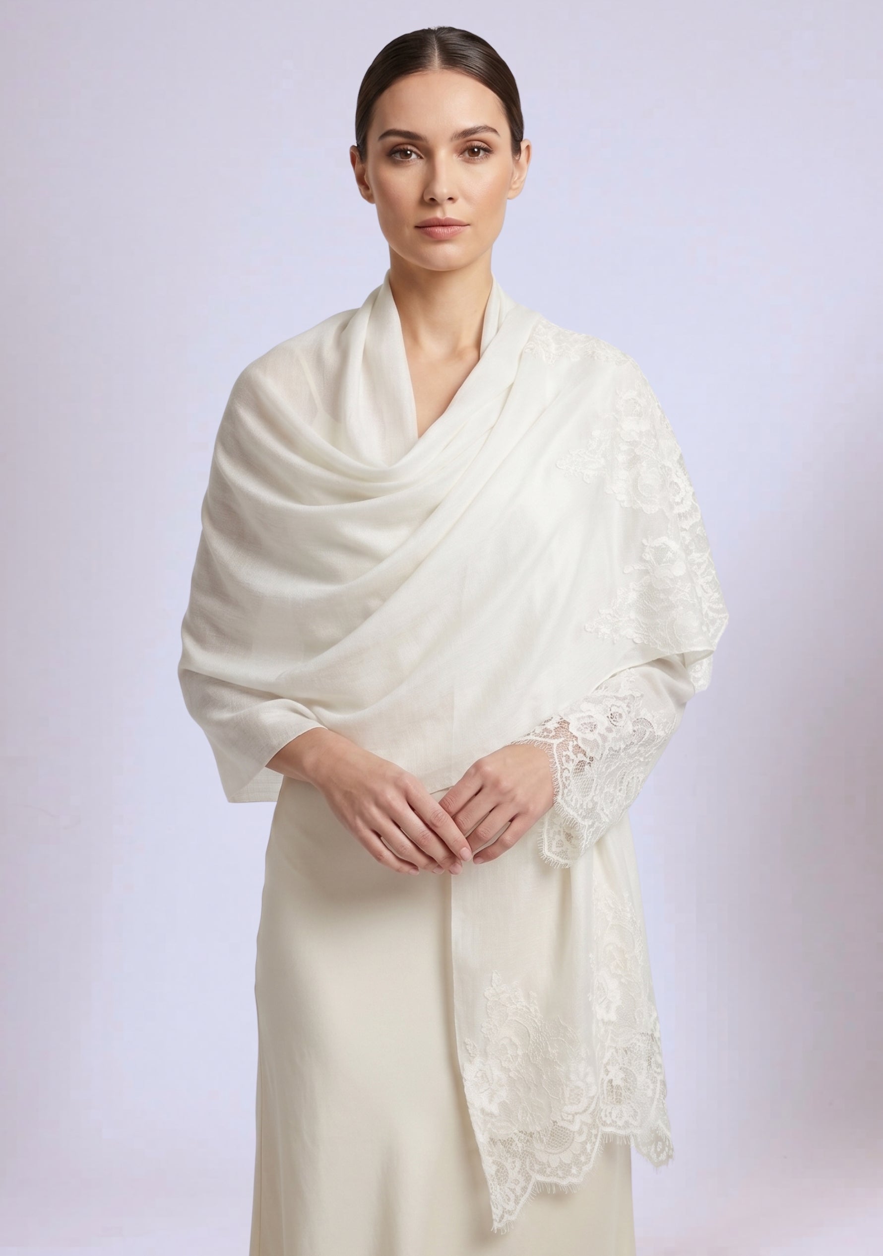 Woman wearing a white shawl with lace details on a light gray background