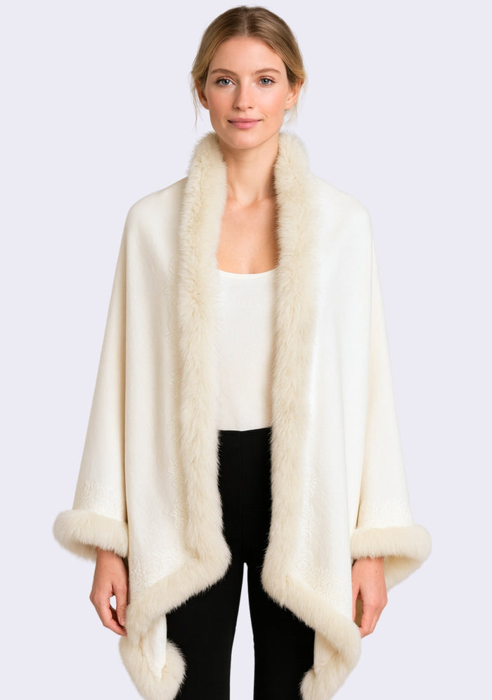 Woman wearing a cream fur-trimmed coat on a white background