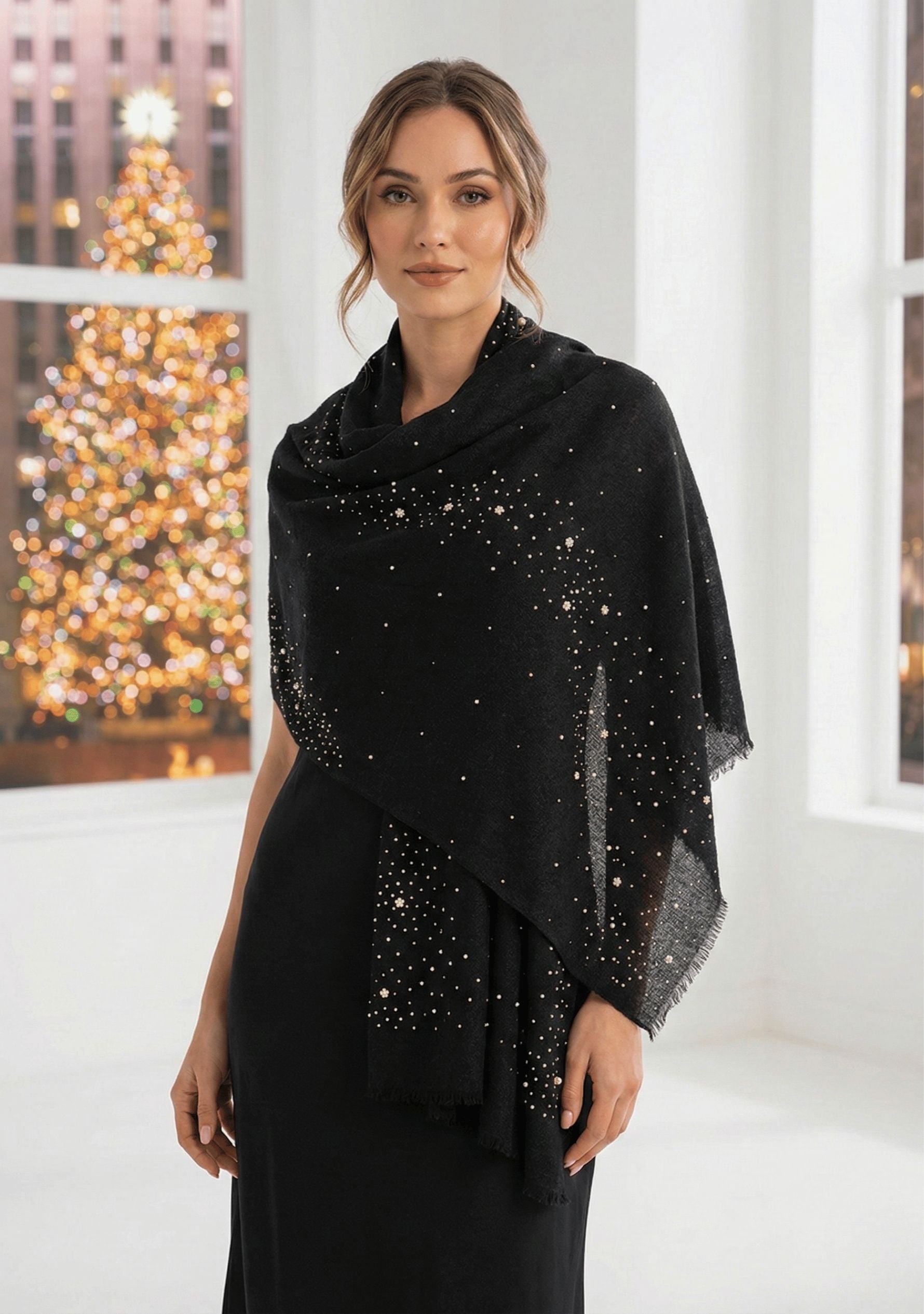 Woman wearing a black shawl with silver embellishments in a festive indoor setting.