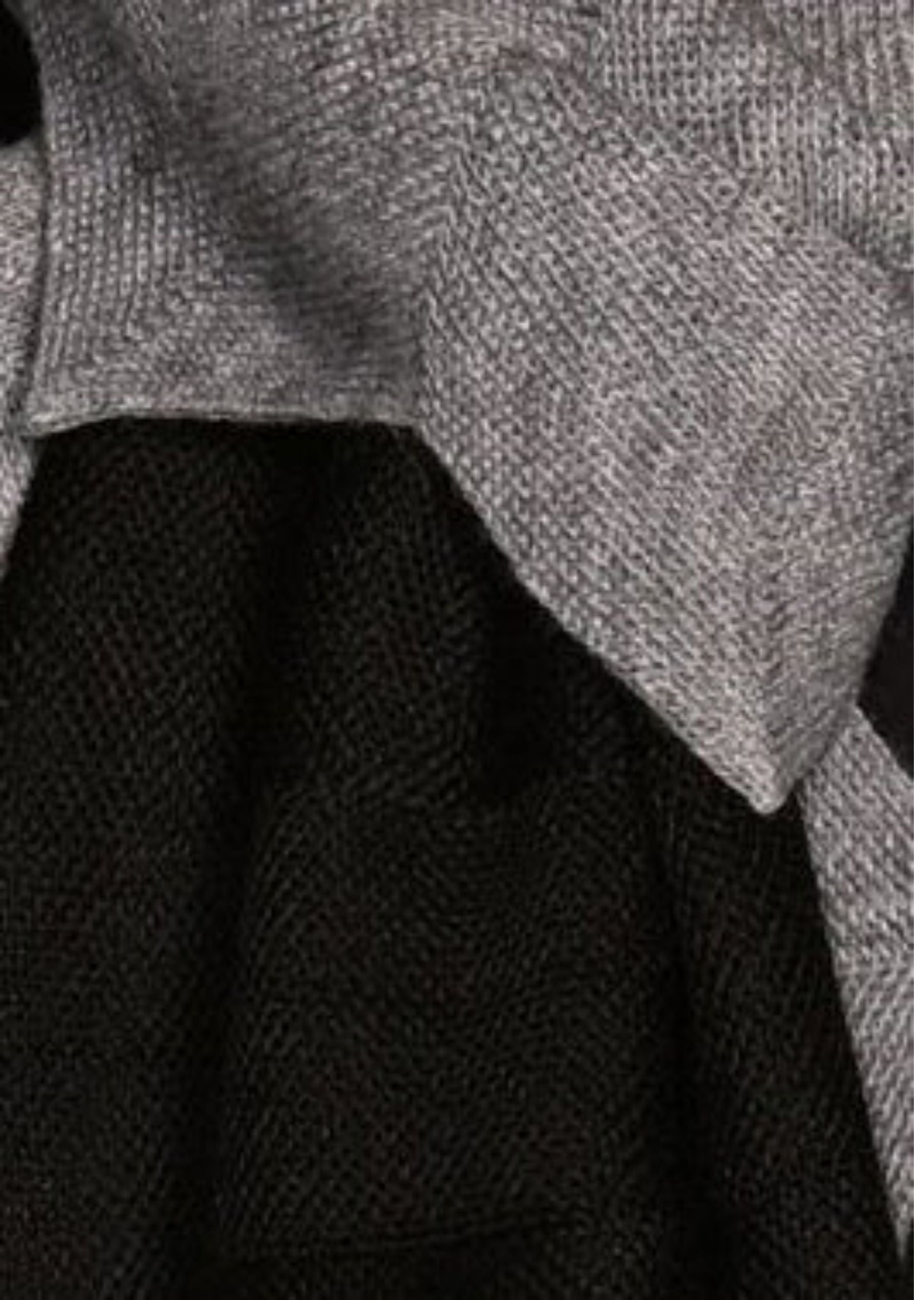 Close-up of a textured gray fabric with a black background