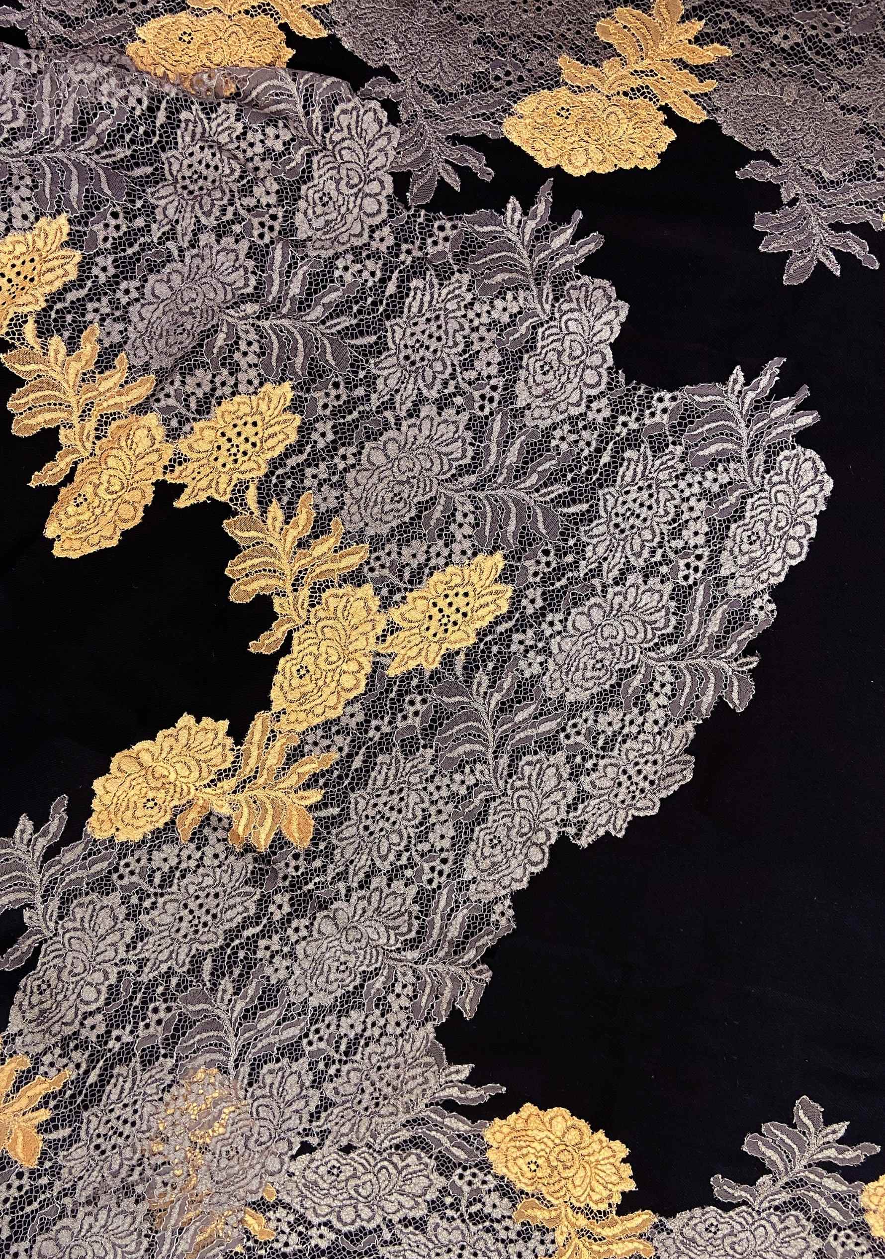Decorative fabric with gold and silver floral patterns on a black background