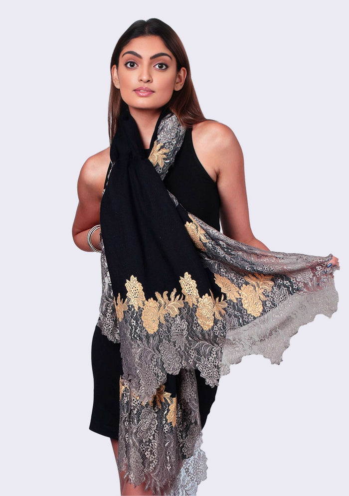 Woman wearing a black dress with a floral lace shawl on a white background