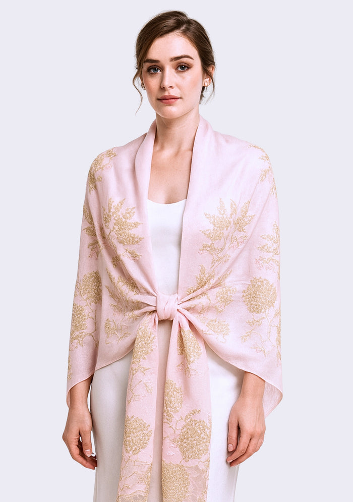 Woman wearing a light pink floral-patterned scarf on a white background