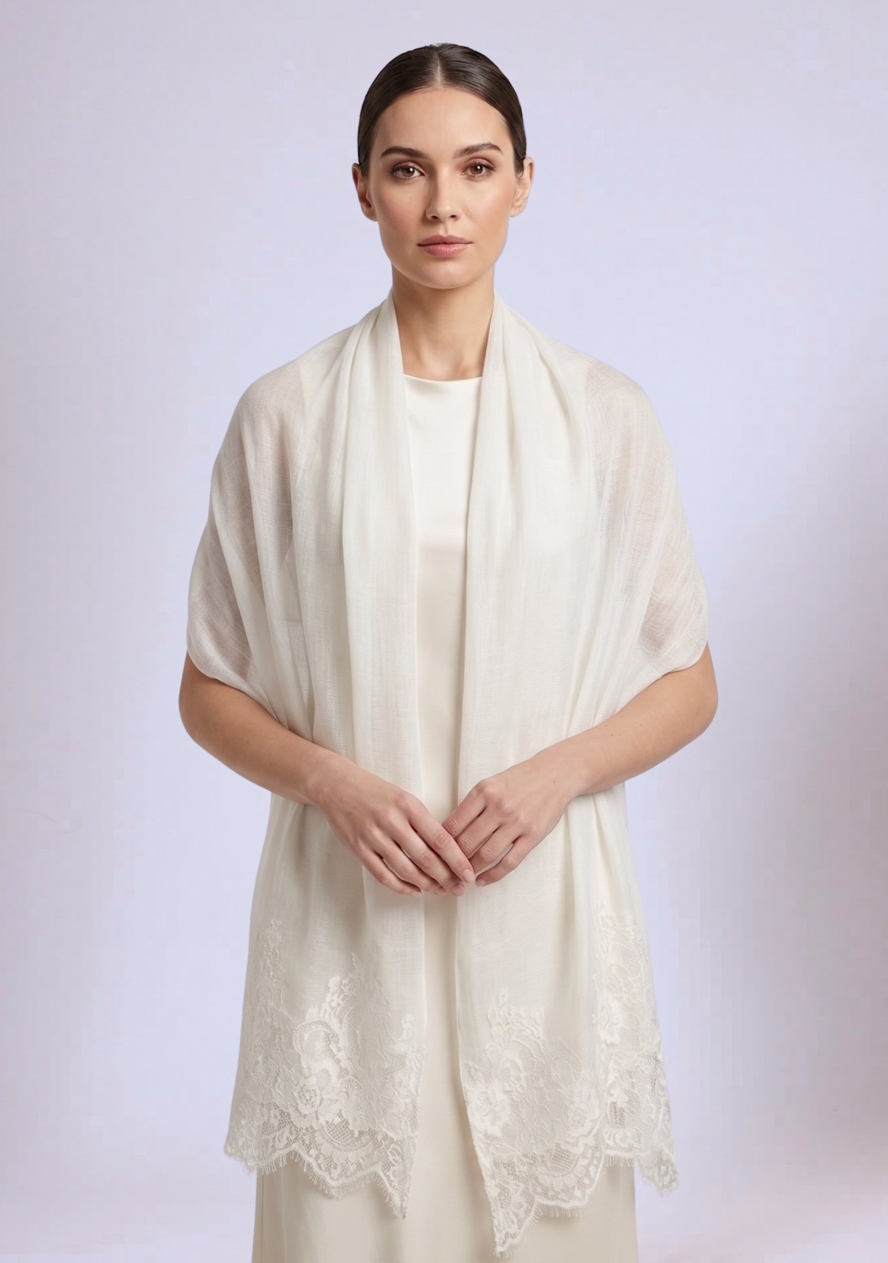 Woman wearing a cream-colored scarf with lace details on a light background