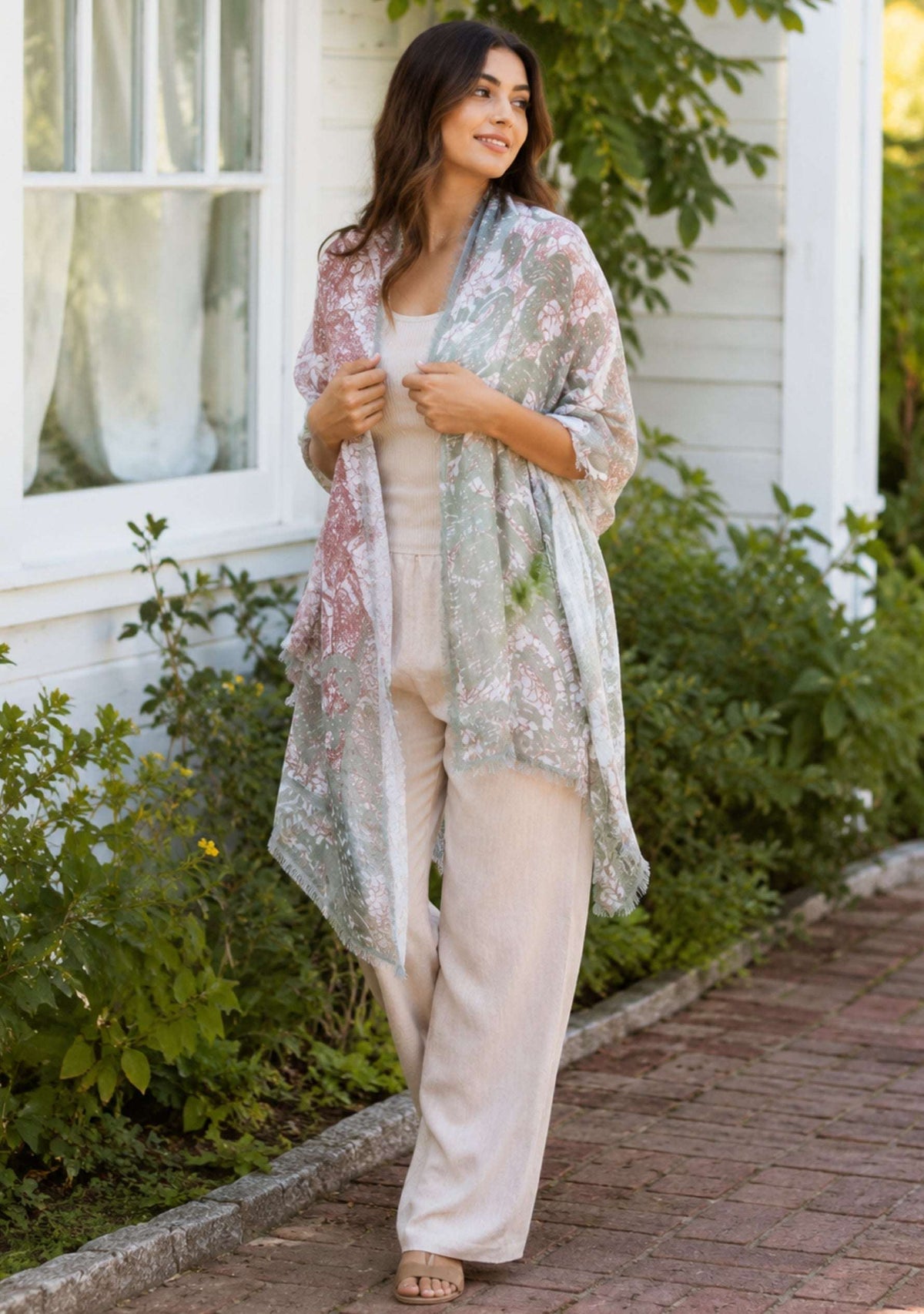 Woman wearing a floral kimono-style garment in a garden setting