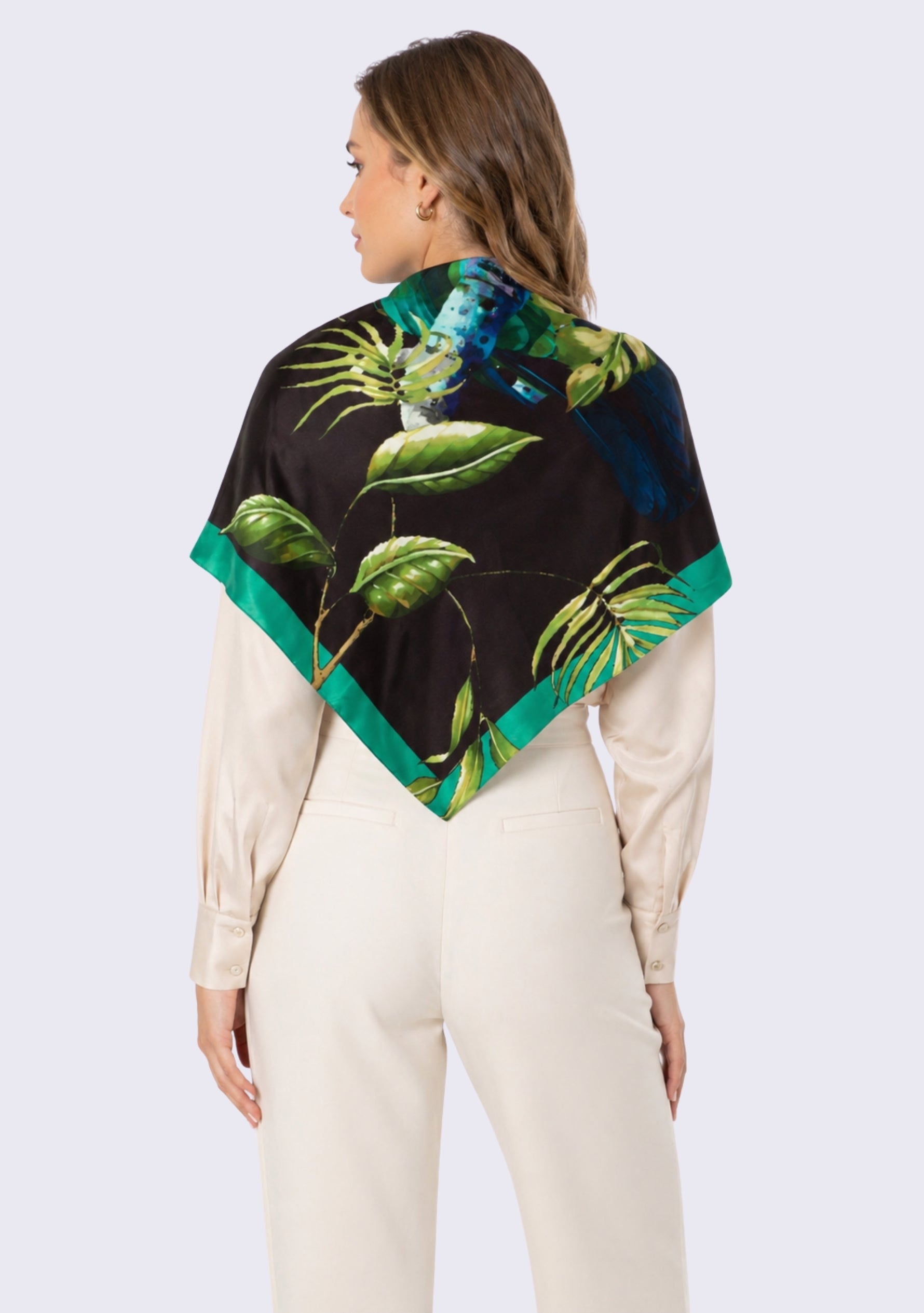 Woman wearing a black scarf with green leaf pattern on a white background
