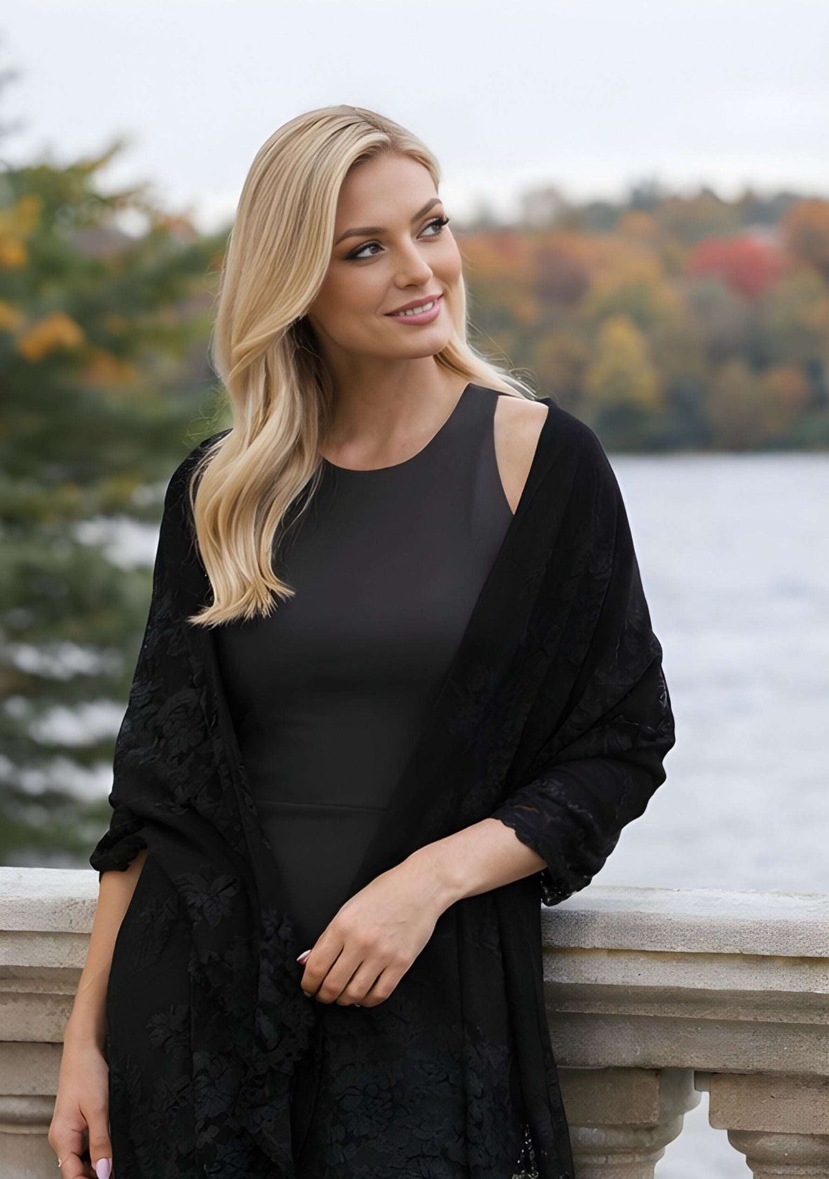 Elegant woman wearing a luxury black cashmere scarf with handcrafted black Chantilly lace while strolling outdoors, showcasing timeless sophistication for evening events, travel, and elevated everyday style.