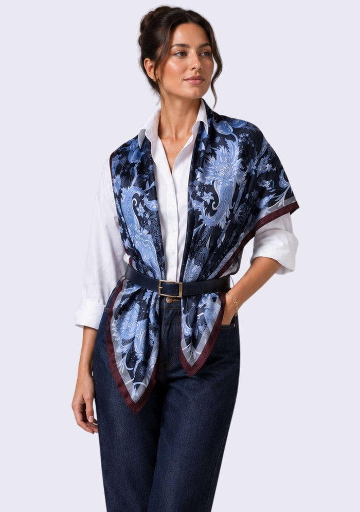 Maneesha Ruia Blue & Brown Jacobean Print Silk Twill Square Scarf with Silver & Gunmetal Swarovski Crystals styled as an elegant silk vest over an ivory shirt with tailored denim.