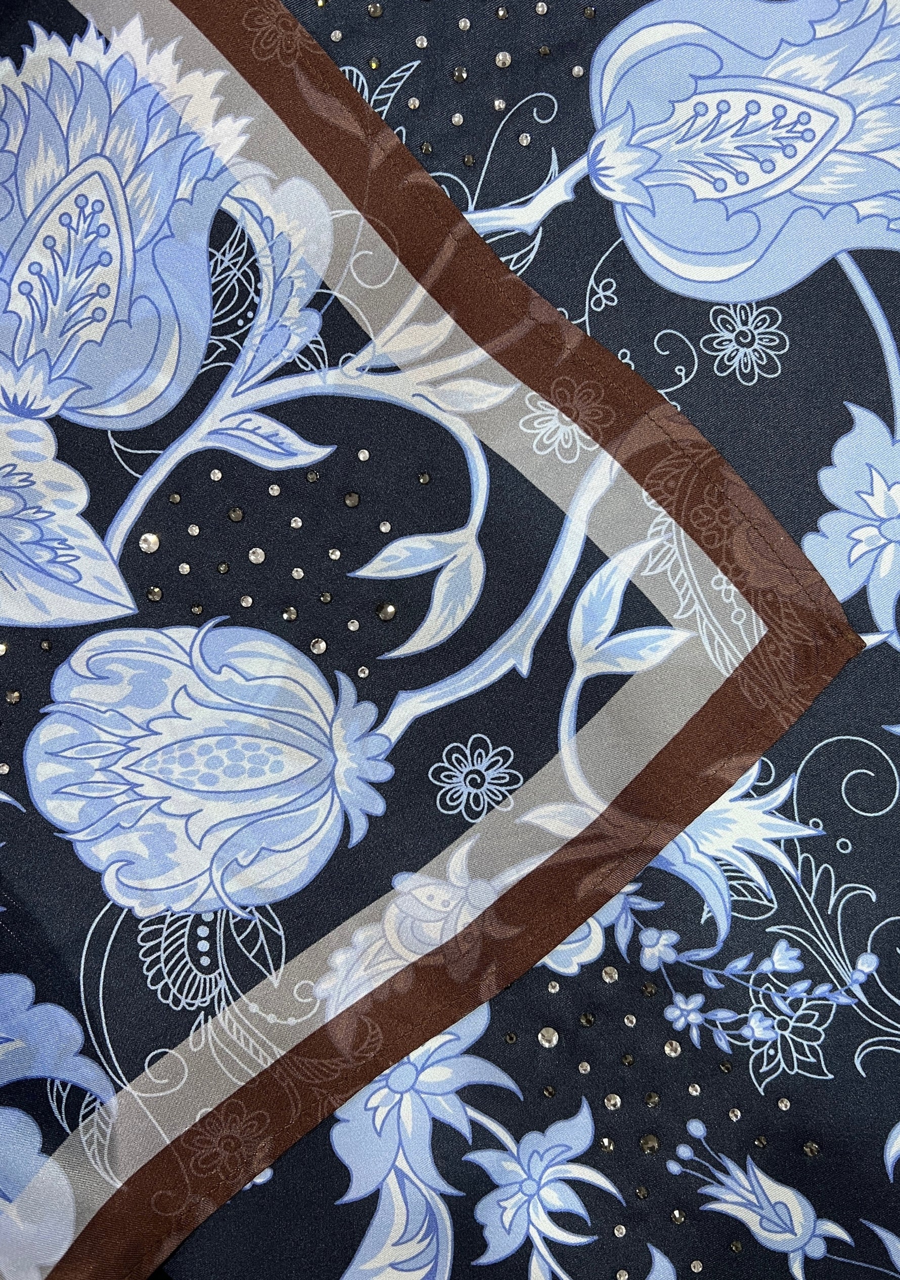 Close-up of the Maneesha Ruia Blue & Brown Jacobean Print Silk Twill Square Scarf with Silver & Gunmetal Swarovski Crystals, showcasing the luxurious silk twill fabric, intricate Jacobean floral print, and crystal embellishments.
