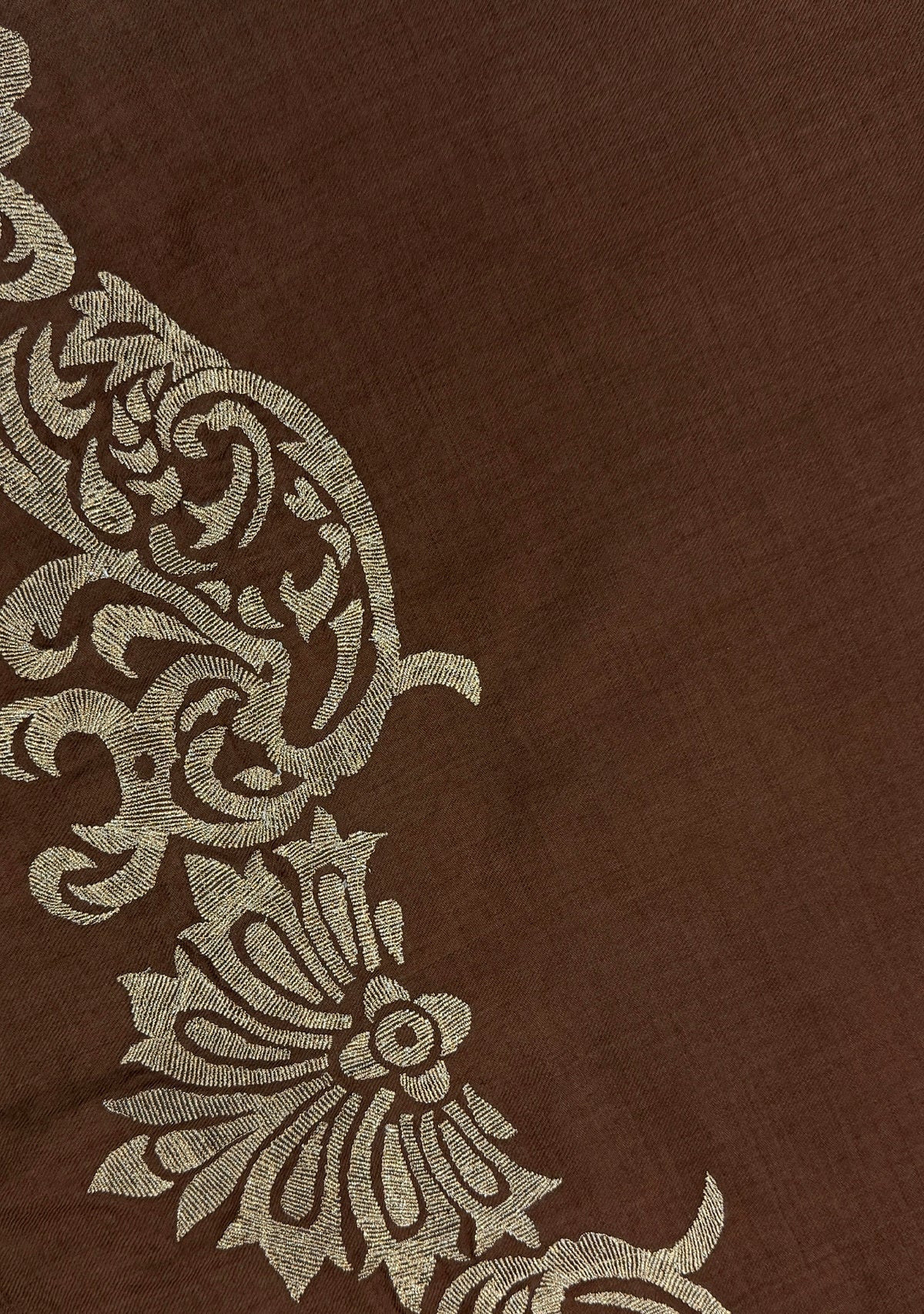 A close-up of a Maneesha Ruia Brown Fine Wool Scarf with gold metallic embroidery and brown fringes