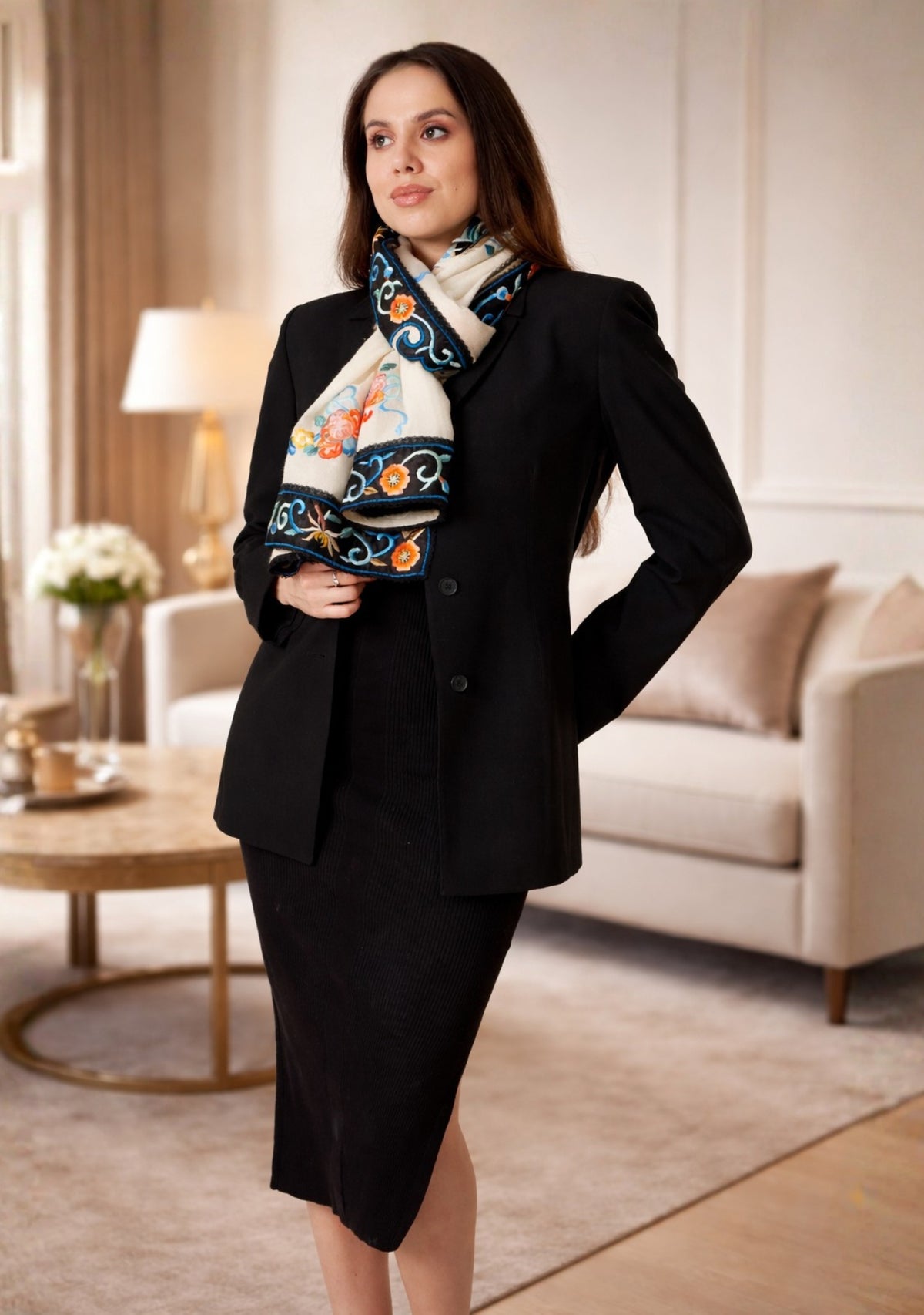 Woman wearing a black suit with a decorative scarf in a living room setting