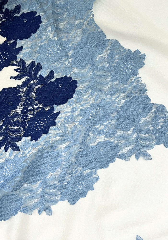 Close-up of a luxury ivory wool and silk scarf featuring handcrafted steel blue and dark denim blue Chantilly floral lace, highlighting the intricate floral lace craftsmanship, rich two-tone detailing, and premium wool-silk fabric.