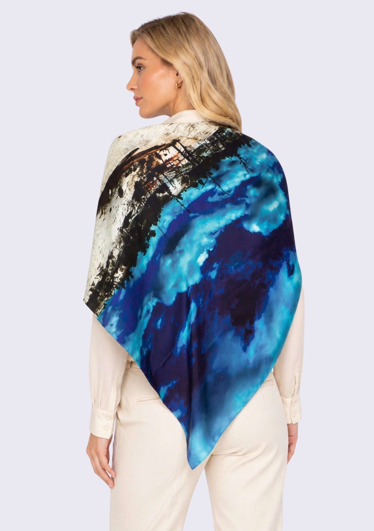 Woman wearing a blue and black abstract patterned scarf on a light purple background