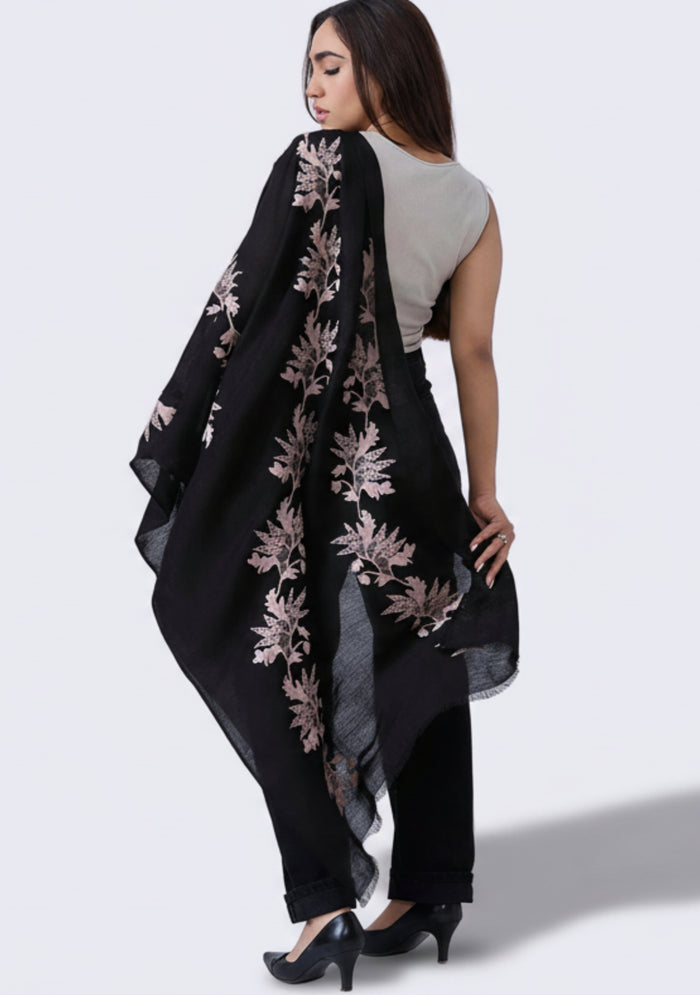 Woman wearing a black scarf with floral patterns on a white background