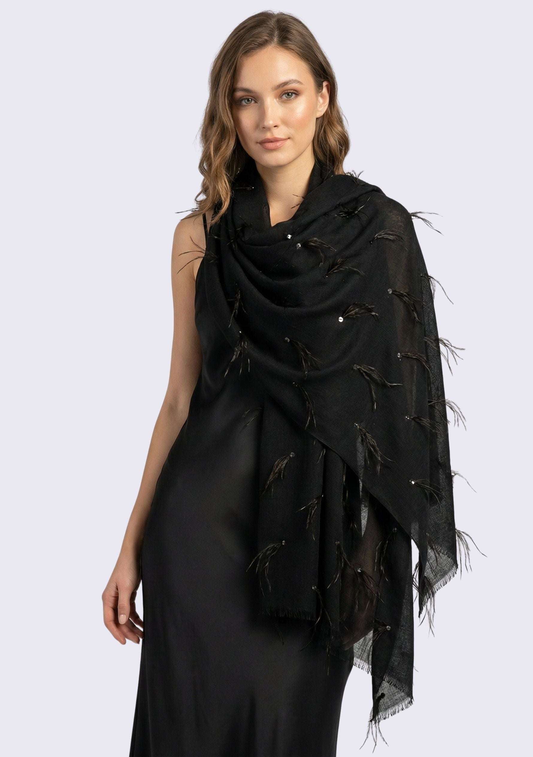 Woman wearing a black scarf with feather details on a white background