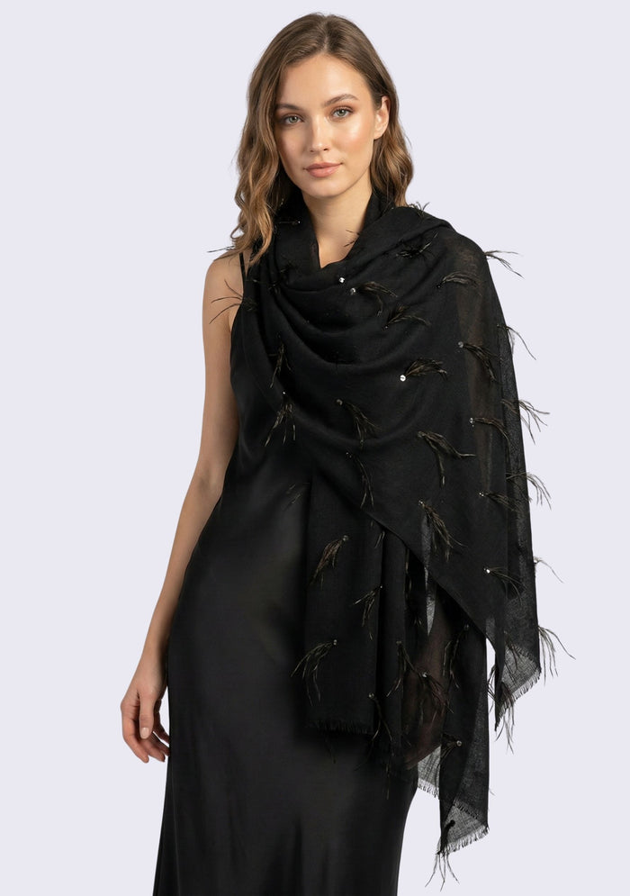 Woman wearing a black scarf with feather details on a white background