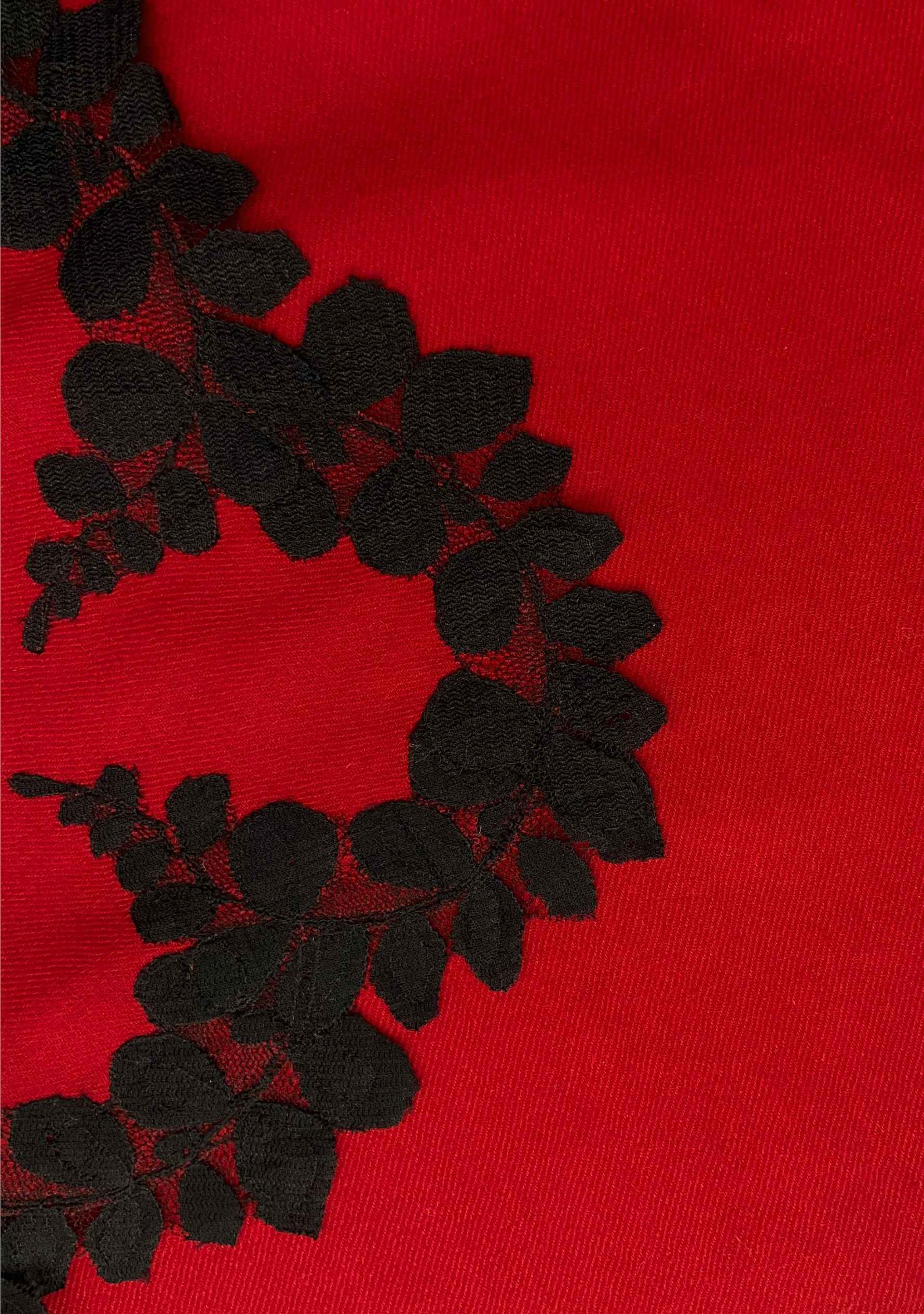 Red fabric with black floral embroidery