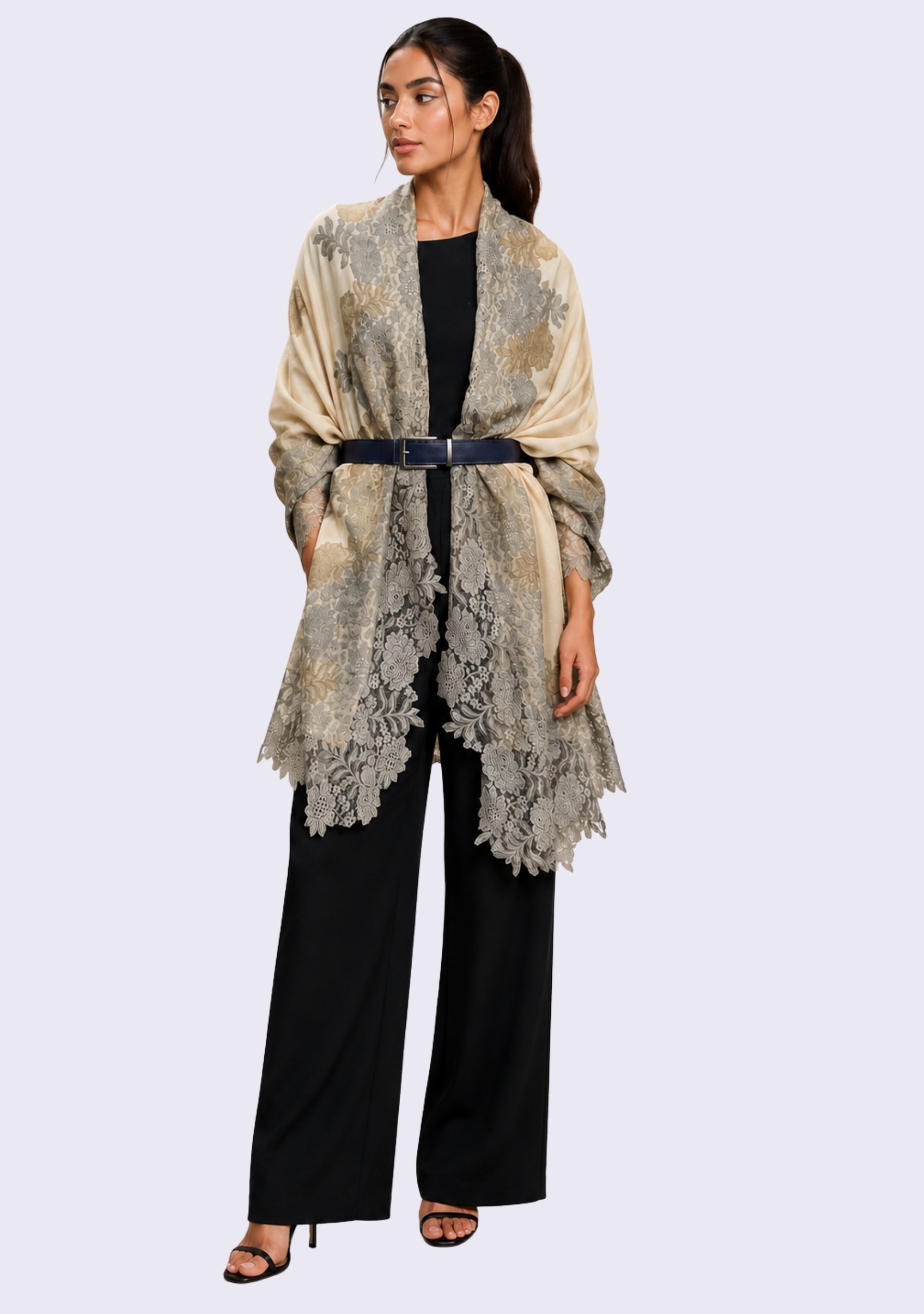 Female model wearing a luxury beige wool and silk scarf with handcrafted mousse and dark beige floral lace, styled as an elegant shawl over a black outfit to showcase its lightweight drape and intricate floral lace craftsmanship.