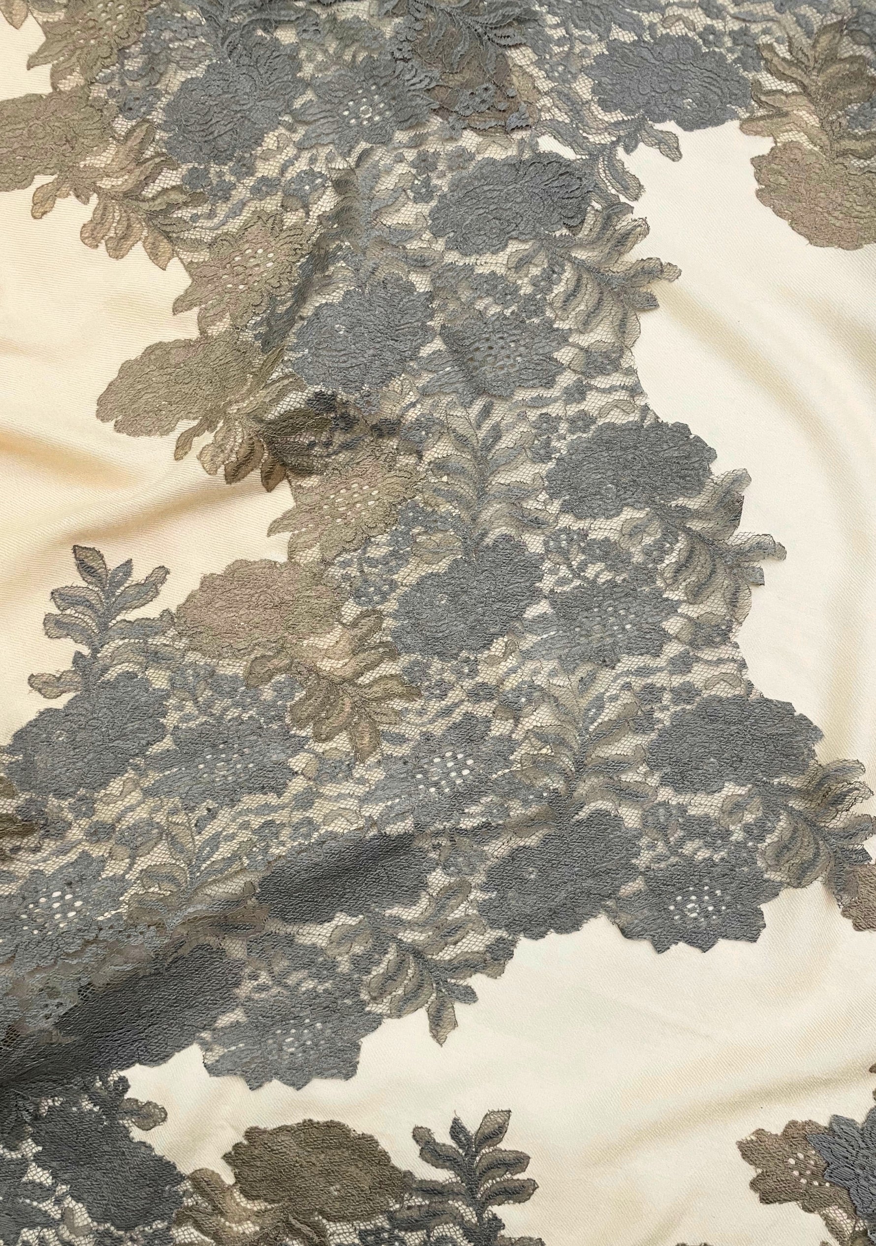 Close-up of a luxury beige wool and silk scarf featuring handcrafted mousse and dark beige floral lace, highlighting the intricate lace craftsmanship, delicate floral pattern, and premium wool-silk fabric.