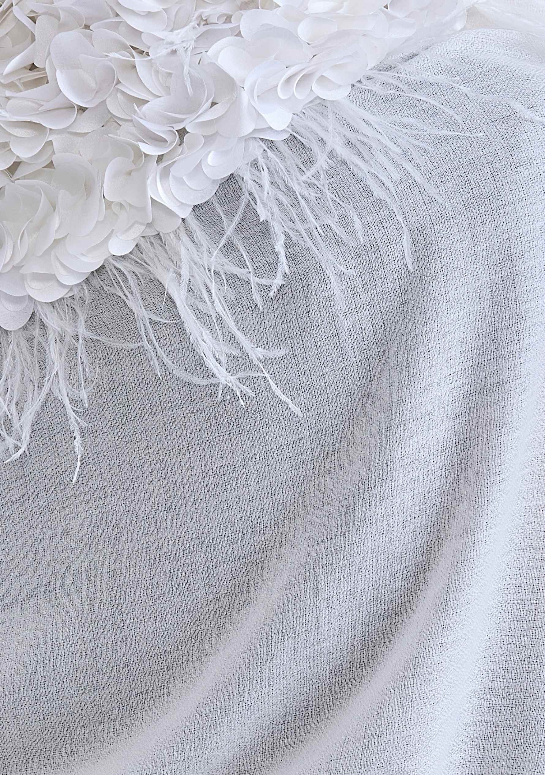 Close-up of a  Maneesha Ruia ivory cashmere scarf with ivory feather and satin appliqué, a luxury designer bridal scarf for women