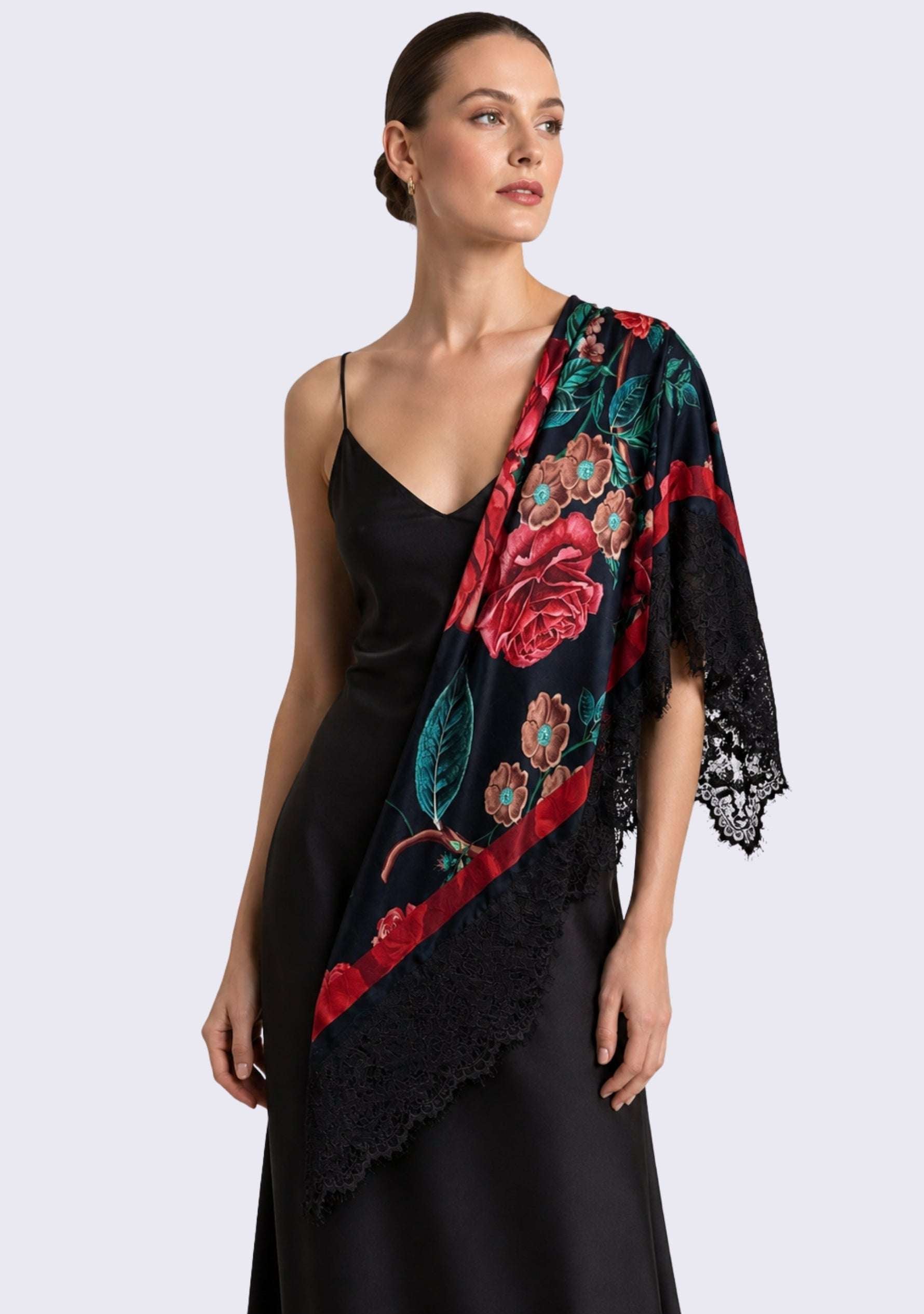 A woman modeling a black satin slip dress with a draped Maneesha Ruia Red Roses Print Silk Square Scarf — red rose print with black lace border in silk twill