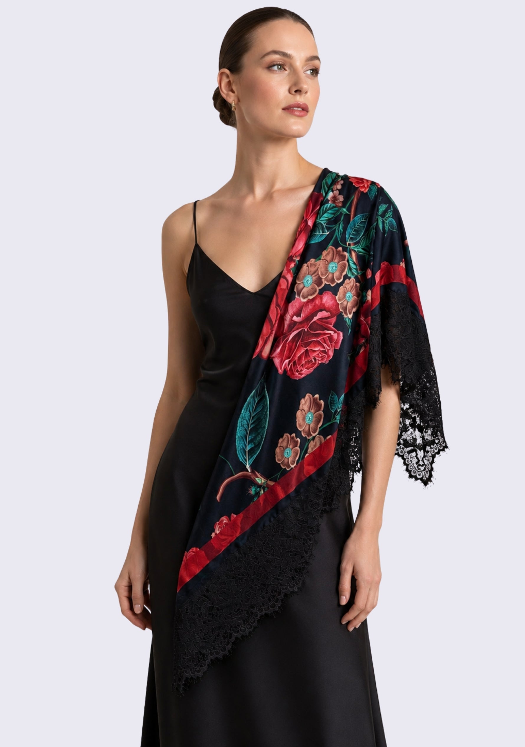 A woman modeling a black satin slip dress with a draped Maneesha Ruia Red Roses Print Silk Square Scarf — red rose print with black lace border in silk twill