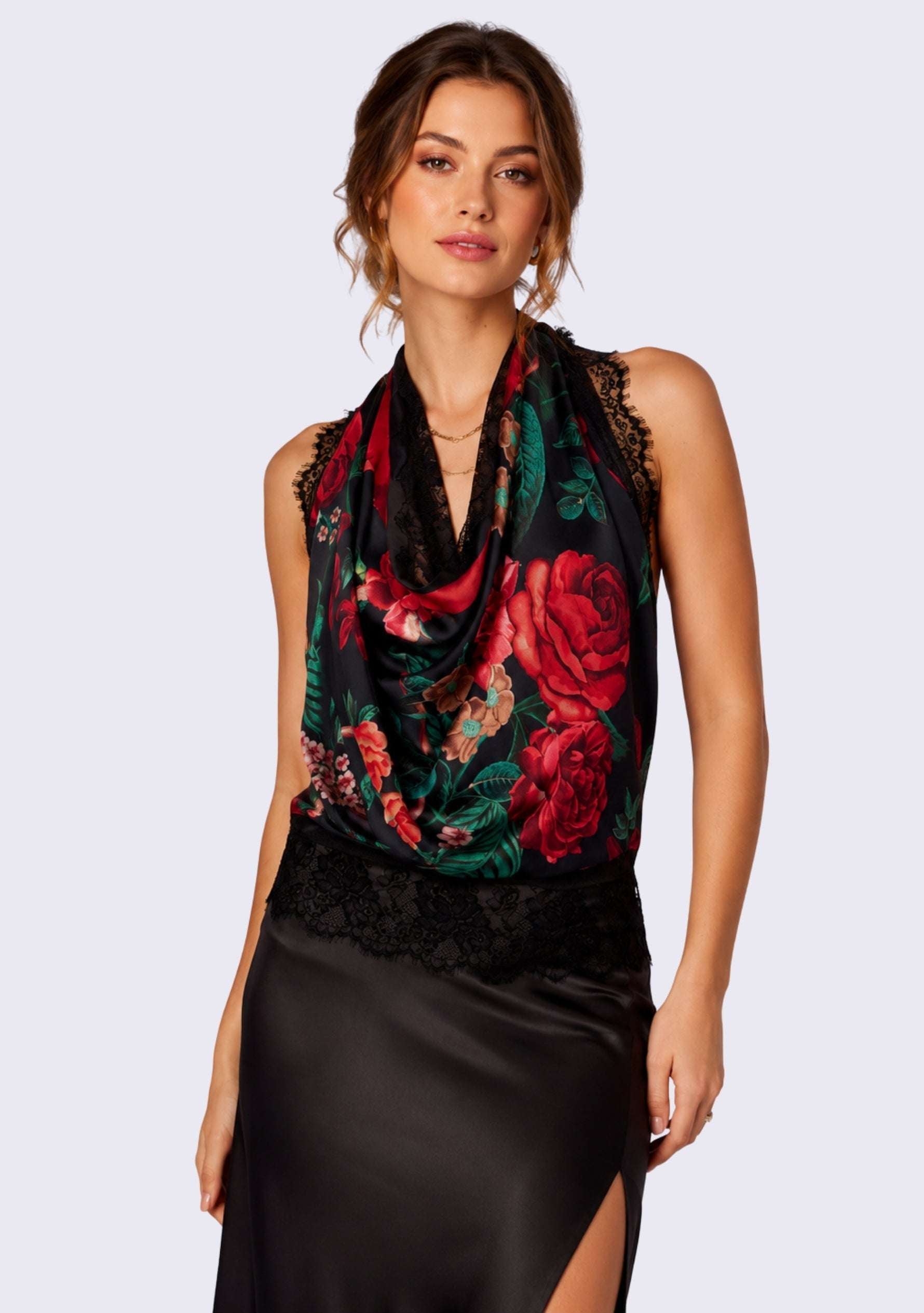 A woman modeling a sleeveless black cowl-neck top with a vibrant Maneesha Ruia Red Roses Print Silk Square Scarf — red rose print with black lace border in silk twill