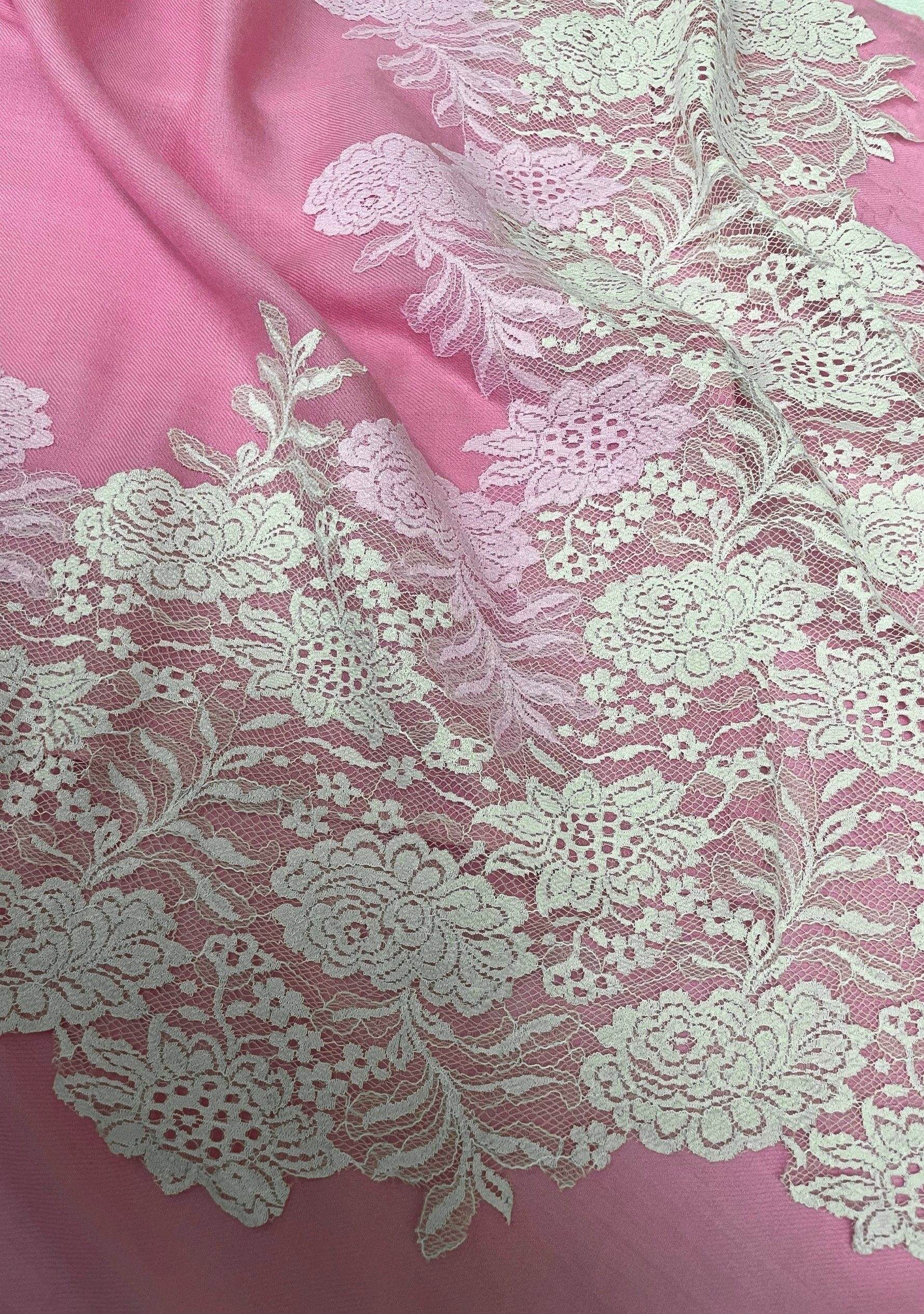 Close-up of a luxury rose pink wool and silk scarf featuring handcrafted ivory and soft pink Chantilly floral lace, highlighting the intricate floral lace craftsmanship, delicate detailing, and premium wool-silk fabric.