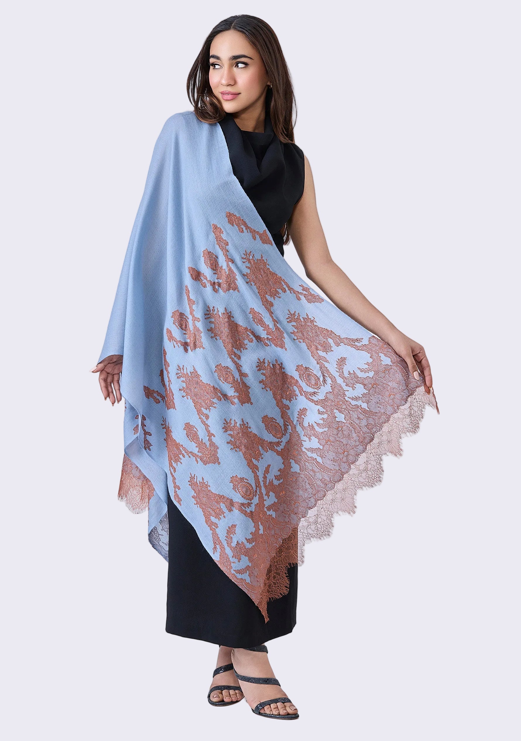 Woman holding a Maneesha Ruia Steel Blue Cashmere Scarf — mocha mousse filigree lace appliqué on luxuriously soft cashmere against a white background