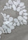 Close-up of white lace fabric with leaf patterns on a gray background