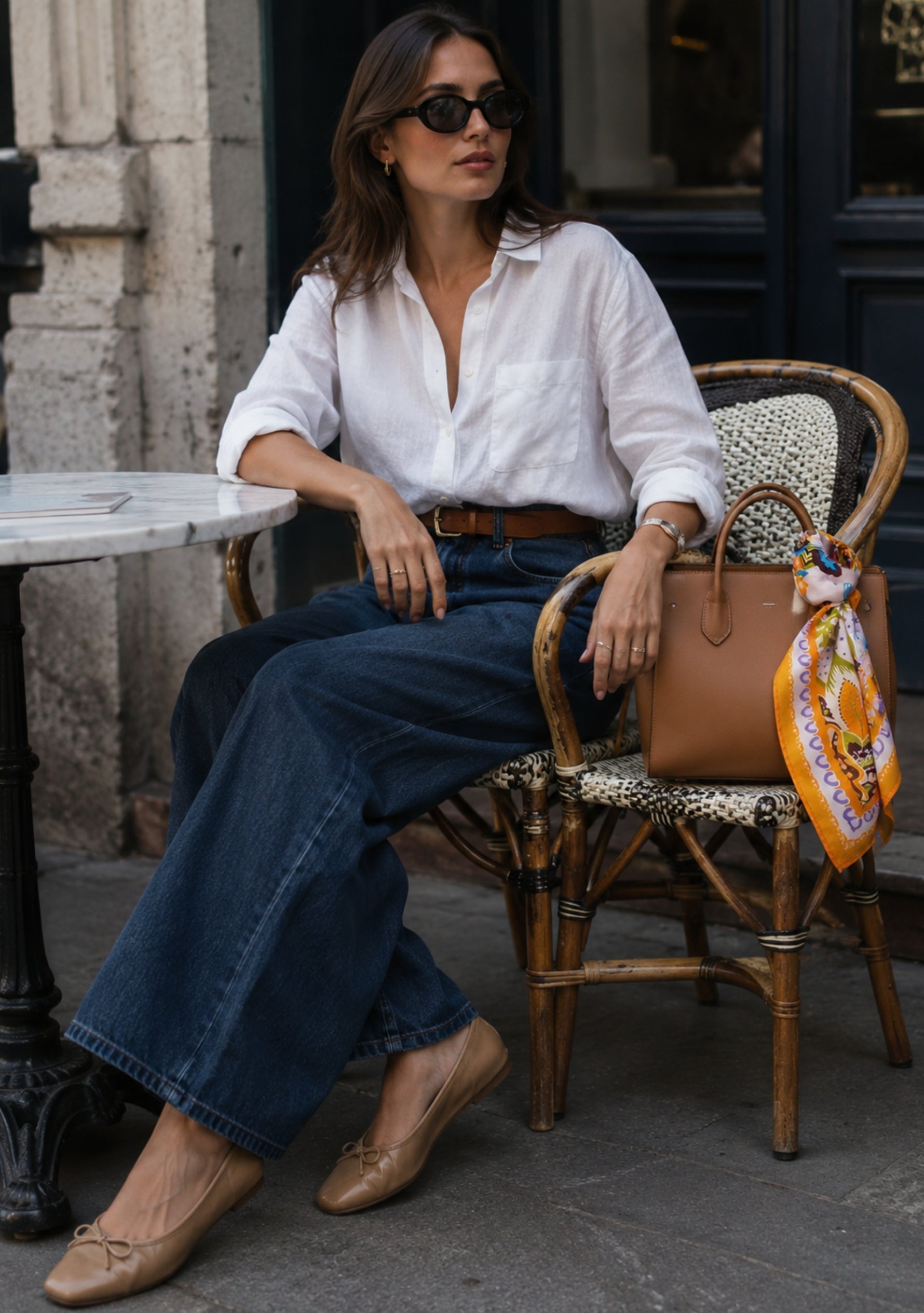 Woman sitting outdoors with  Multi Chintz Print Silk Square Scarf with Lavender Swarovski Crystals styled on a luxury leather handbag for an elegant everyday look.