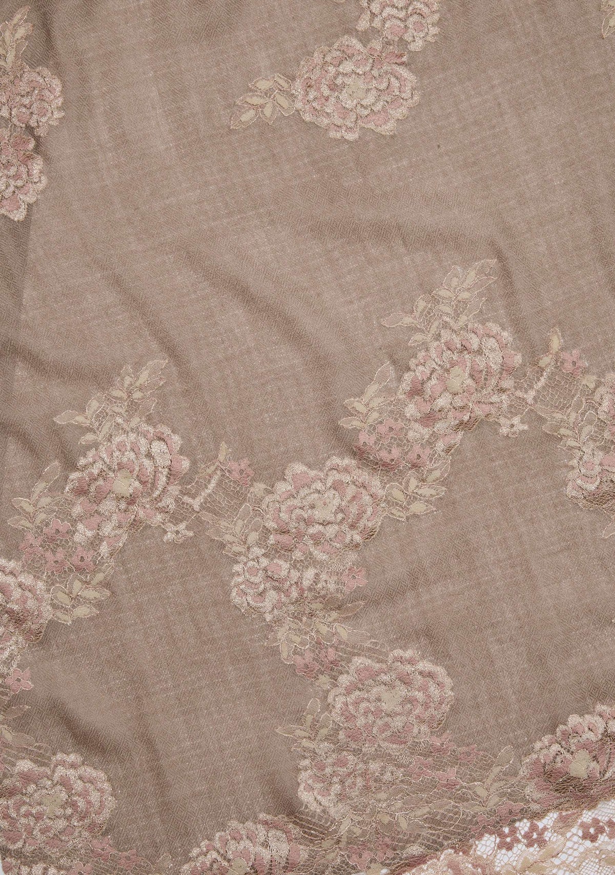 A woman wearing a natural color cashmere scarf with dual shade copper Chantilly lace,