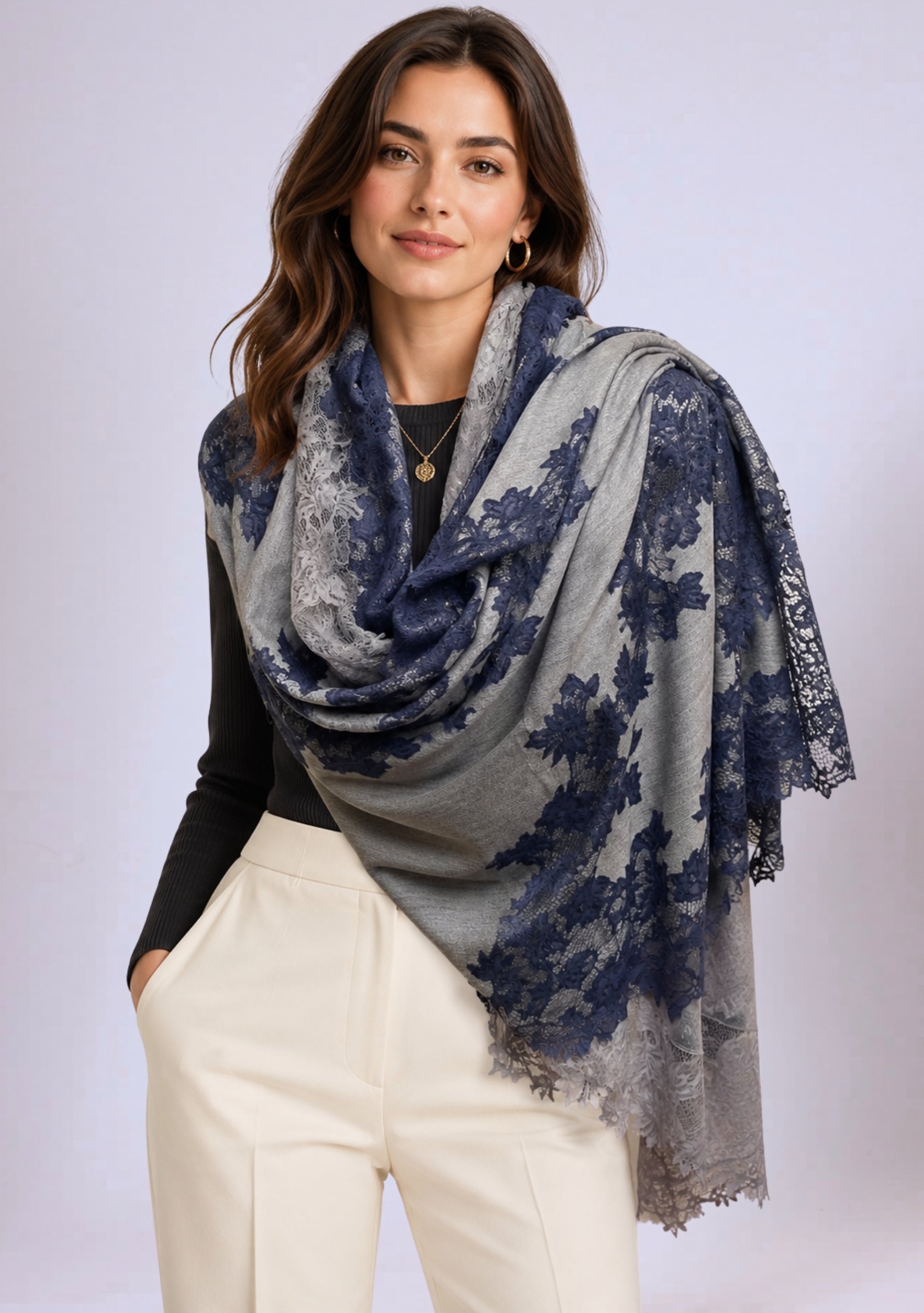 A woman wearing a gray and blue floral patterned scarf on a plain background