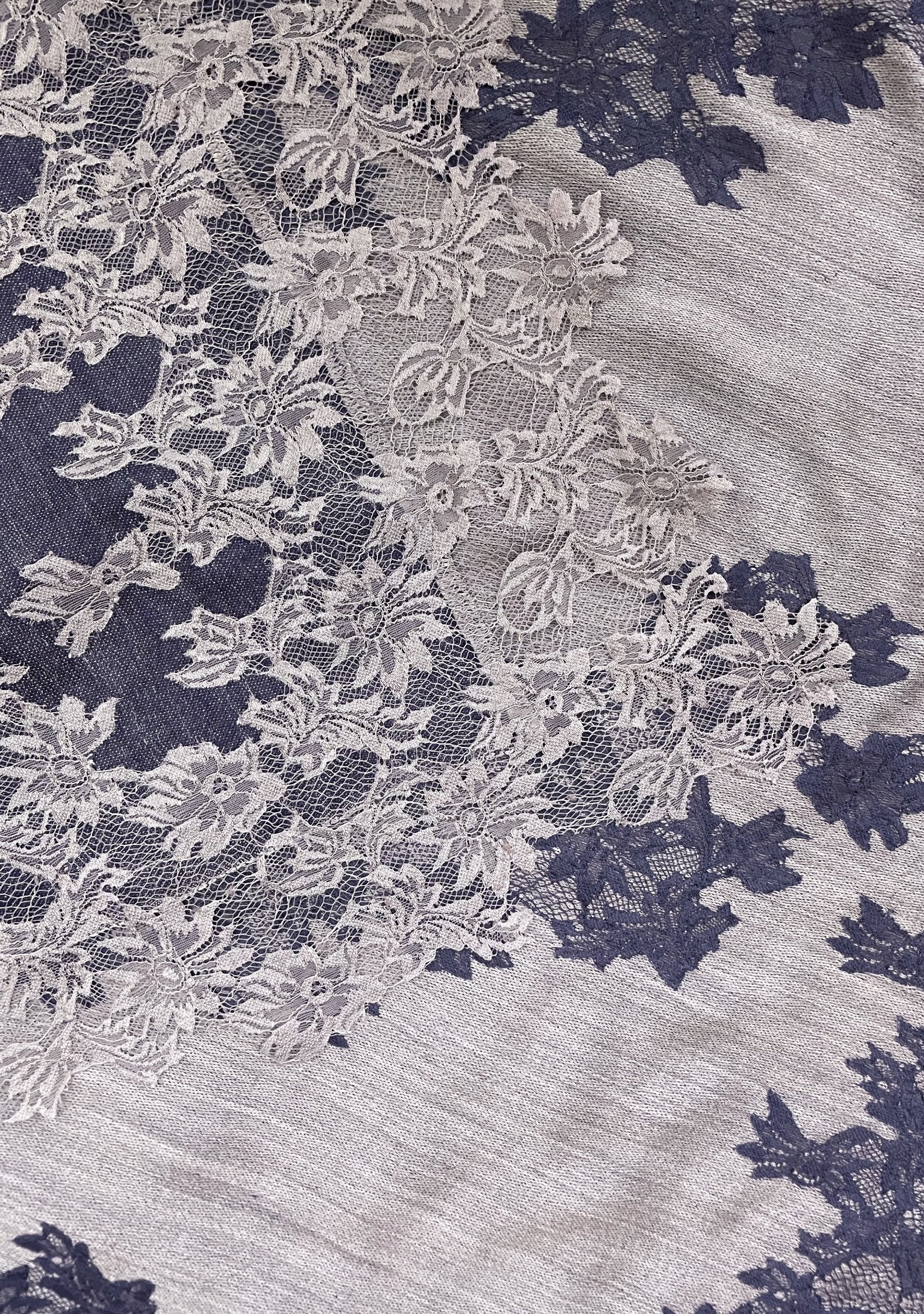 Close-up of a floral lace trim scarf with a dark background